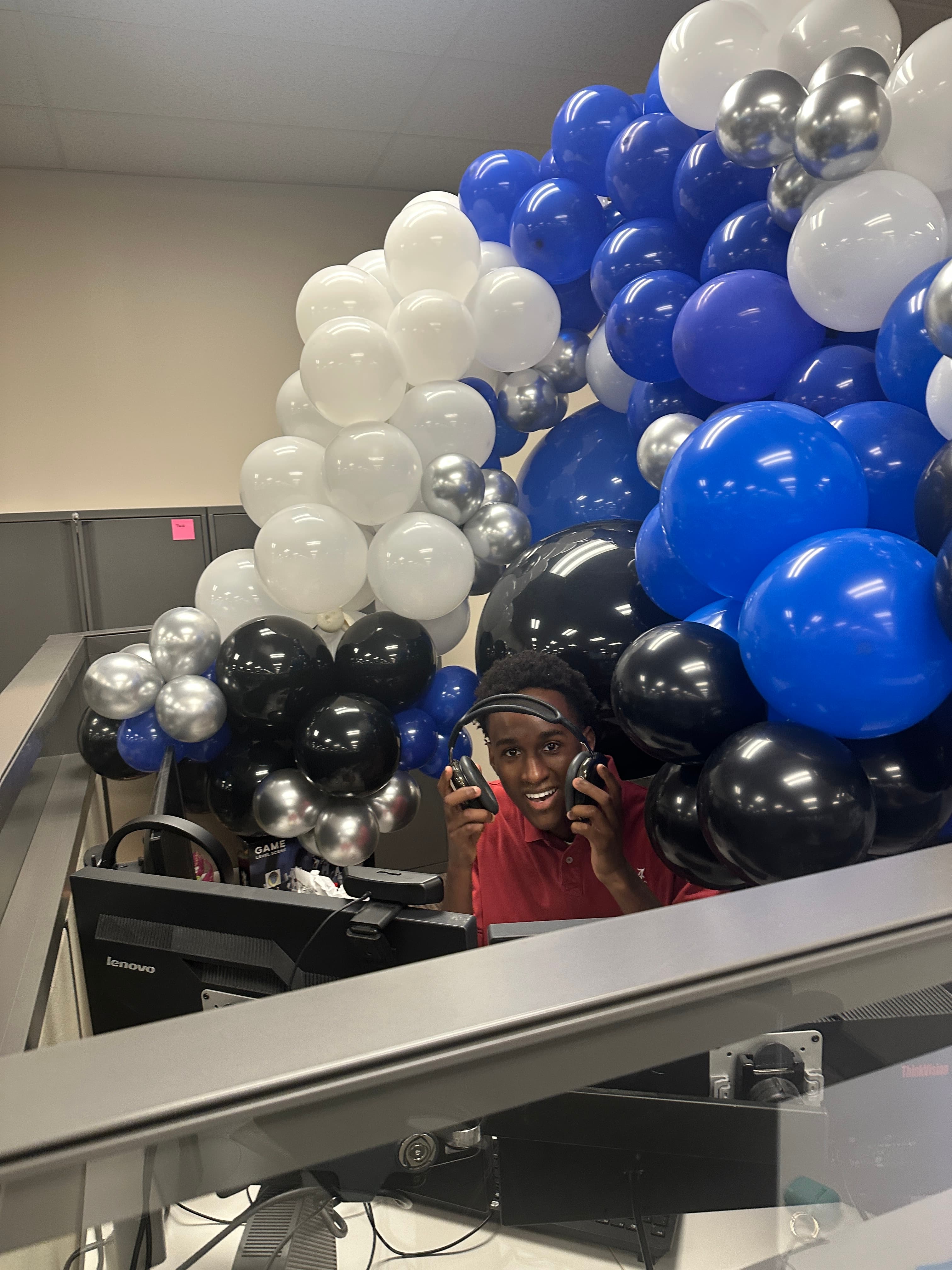 Wesley in his office, filled with balloons